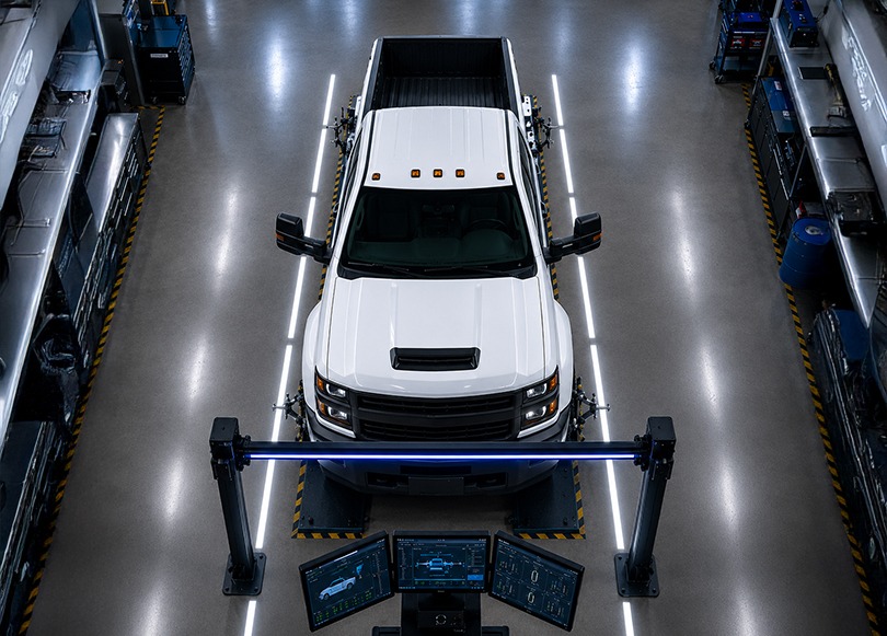 Technician inspecting the underside of a vehicle